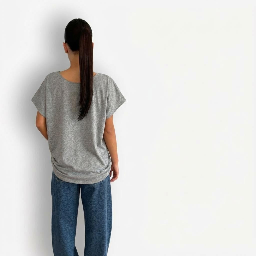 Grey oversized T-shirt styled with high-waisted AGOLDE Luna Barrel jeans, featuring a relaxed, slouchy silhouette on top paired with structured, curved-leg light-wash denim for a modern, effortless look.