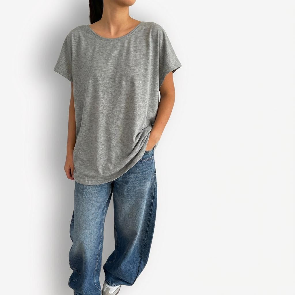 Grey oversized T-shirt styled with high-waisted AGOLDE Luna Barrel jeans, featuring a relaxed, slouchy silhouette on top paired with structured, curved-leg light-wash denim for a modern, effortless look.