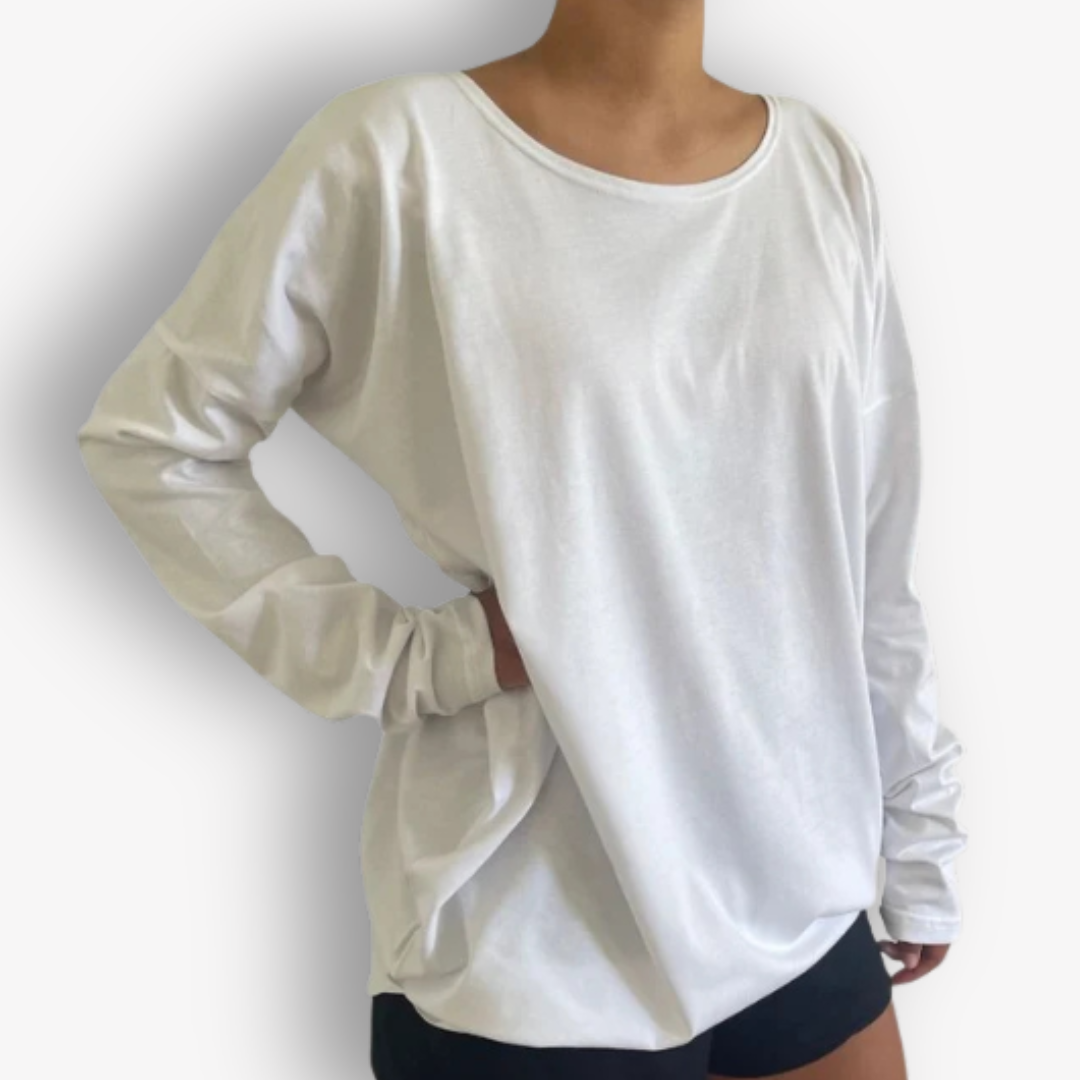 A woman wearing a loose, long-sleeve white t-shirt with ruched detailing on the sleeves, paired with black athletic shorts, shown against a plain white background.
