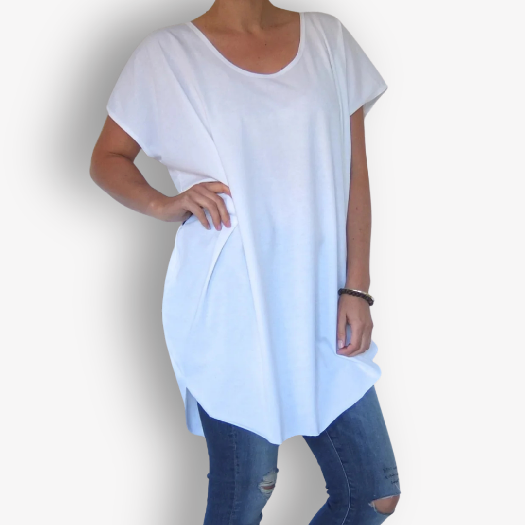 A woman wearing a loose white short-sleeve tunic top with a scoop neckline, paired with blue distressed jeans, shown against a plain white background.
